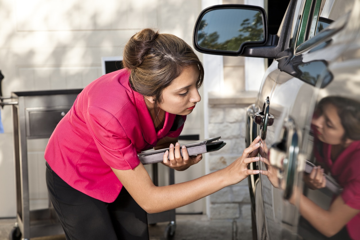 Insurance adjuster inspecting damage to vehicle.