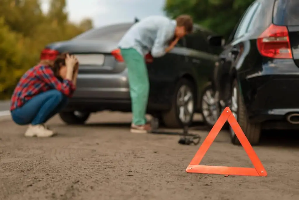 Scene of a car accident with two people showing distress, highlighting the emotional impact of such events and the need for an experienced car accident attorney. 